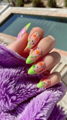 Naklejka premium Brightly colored nails feature pastel pink and neon green, decorated with dots, while a person relaxes beside a sparkling pool