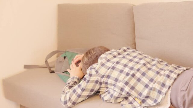 10-year-old boy in frustration, lying on sofa, punching pillows, experiencing teenage angst and tantrums, coping with emotions, angst and frustration, mental health
