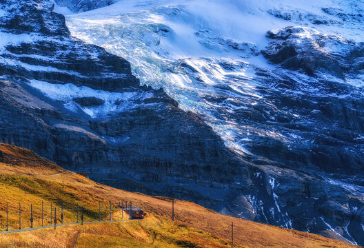 Train driving through Lush alpine landscape in Swiss Alps in summer with a glacier in the background, Kleine Scheidegg, Switzerland