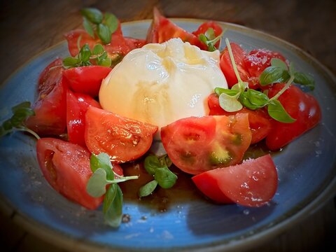 Close-up of a burrata and tomato salad with basil, sea salt and balsamic vinegar