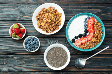 Healthy breakfast . Yogurt with berries ( strawberry , raspberry , blueberry , blackberry ) , granola and chia seeds . Top view