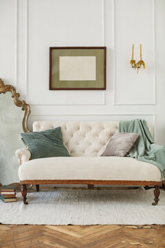 Empty picture frame on a wall by a mirror and sofa in a stylish living room