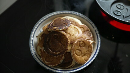 Top view of a plate of smiley face pancakes, freshly made and ready to serve. The image highlights a playful and creative approach to breakfast, perfect for a fun morning meal