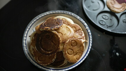 Top view of a plate of smiley face pancakes, freshly made and ready to serve. The image highlights a playful and creative approach to breakfast, perfect for a fun morning meal