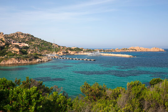 View over calm turquoise water to Porto Massimo and the rocky headland of Punta Lunga, La Maddalena Island, La Maddalena Archipelago National Park, Sassari, Sardinia, Italy, Mediterranean