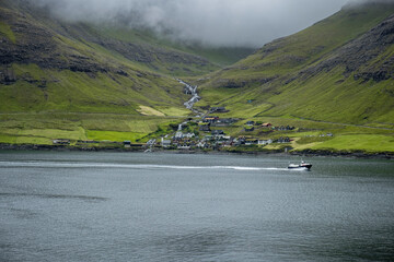 A small village nestled in the green mountains of the Faroe islands, Denmark