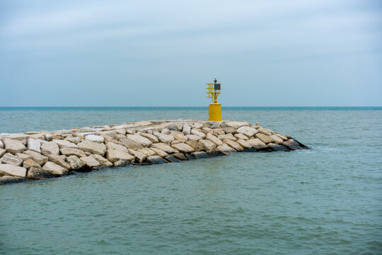 Yellow lighthouse on a cloudy day in Rimini, Emilia-Romagna, Italy