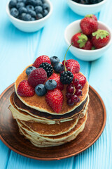 Stack of homemade american pancakes with berries . Top view