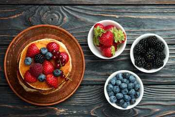 Stack of homemade american pancakes with berries . Top view