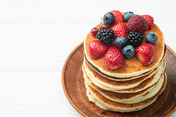 Stack of homemade american pancakes with berries . Top view