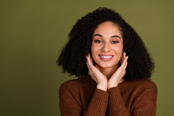 Portrait of pretty young woman touch face empty space wear sweater isolated on khaki color background