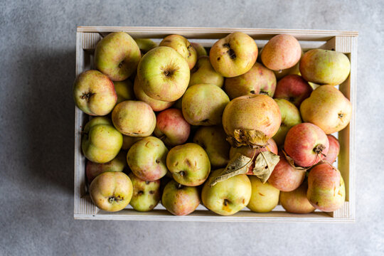 Overhead view of freshly harvested organic apples in a wooden crate
