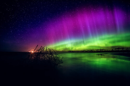 Purple and green northern lights over the Sventoji old pier (Sventosios senasis molas), Sventoji, Palanga, Lithuania