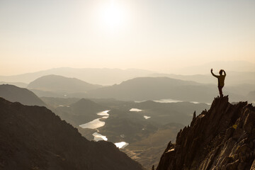 Obraz premium A man is standing on a mountain top, taking a selfie