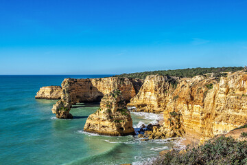 Obraz premium Praia da Marinha Beach among rock islets and cliffs seen from Seven Hanging Valleys Trail, Algarve, Portugal