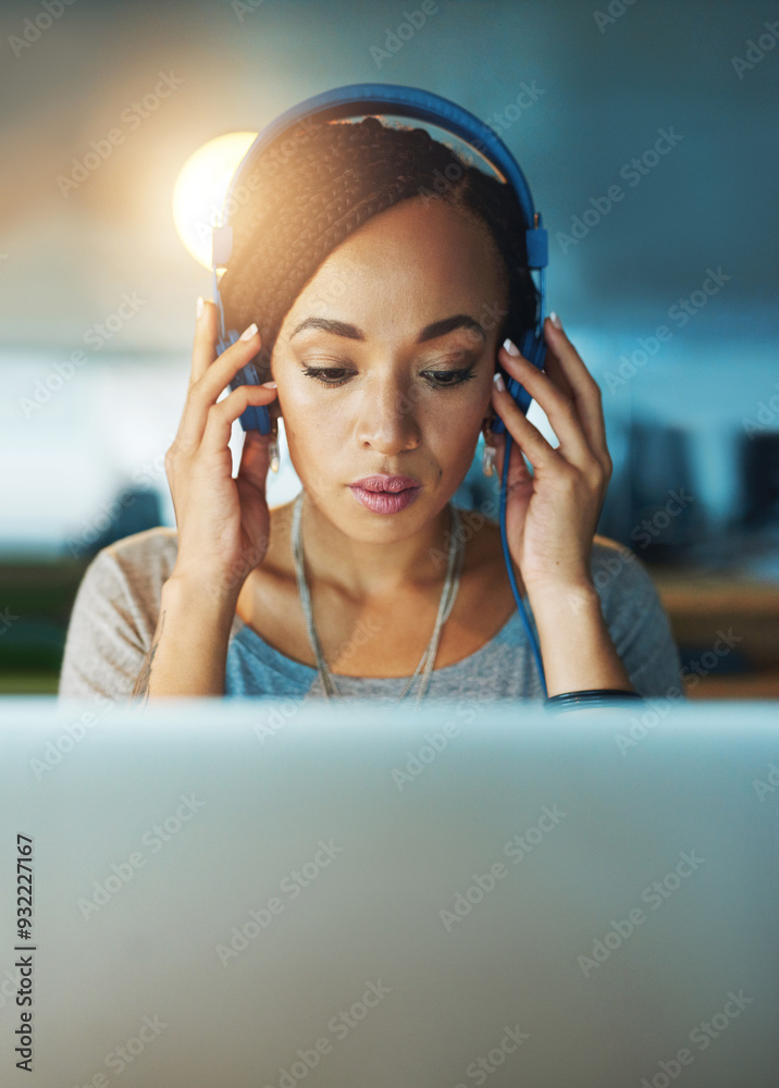 Wall mural African woman, laptop and headphones in office for planning, commitment and project deadline at night. Web designer, technology and music in workplace for radio, streaming and research inspiration