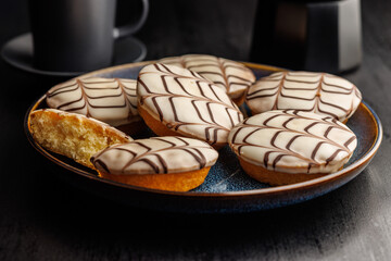 Sweet dessert with sugar coating  on plate on black table.