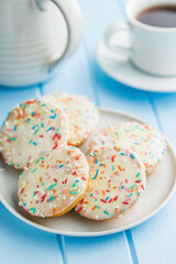 Sweet dessert with sugar coating on plate on blue table.