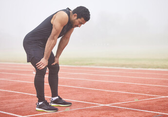 Breathe, fitness and man on track from exercise, marathon training and cardio workout at stadium....