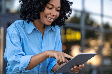 Waist up of a woman with tablet in hands working outdoors