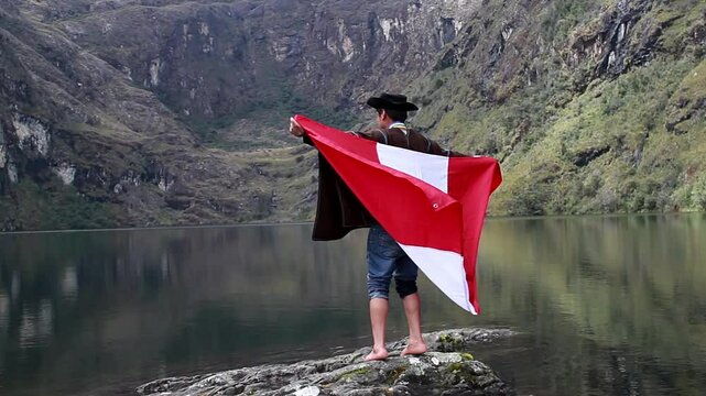 Campesino con Poncho y Sombrero Flamea la Bandera del Per&uacute; en la Laguna.