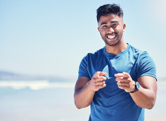 Man, portrait and finger point for fitness on beach, join workout and physical cardio by ocean for health. Mockup space, happy and hand gesture for invitation to come exercise, motivation and space.