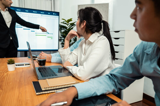 Project manager planning schedules for business task at meeting room, Gantt chart software show on TV screen. Multi ethnic diversity business people and modern business project management. Habiliment