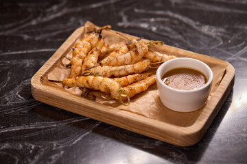 Delicious Grilled Shrimp Accompanied by a Sauce on a Rustic Wooden Platter for Serving