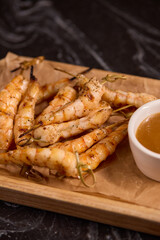 Delicious Grilled Shrimp Accompanied by a Sauce on a Rustic Wooden Platter for Serving