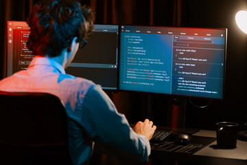 Working IT developer concentrating online software development information on surrounded by coding application pc screens, creating program for firmware on website at neon modern office home. Gusher.