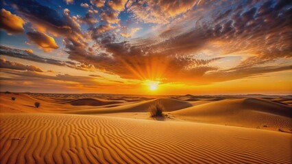 Naklejka premium Vibrant orange sunset casting a warm glow over the sandy desert landscape, sunset, desert, sun, dusk, orange