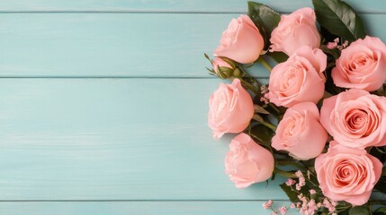 Soft pink roses arranged on a turquoise wooden surface with scattered petals