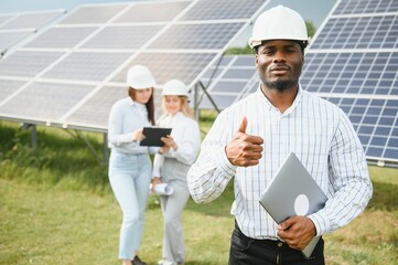 A group of engineers work on a solar panel farm.
