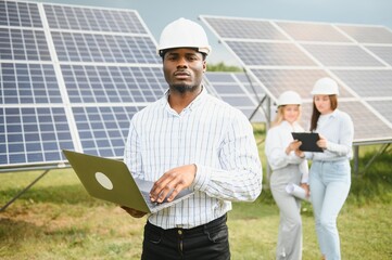 Male and female engineers worker working in solar panels power farm. technician working at solar power station