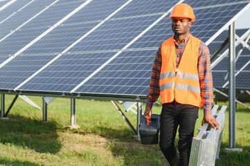 African American electrician worker installs solar panels. Green energy