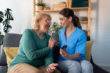 Obraz premium A diligent nurse in blue scrubs assists a gleeful elderly woman with a glucometer, ensuring her well-being in the comfort of her living room.