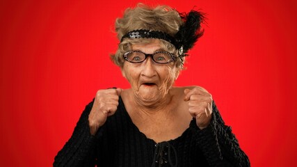 Saying WOW, a portrait of surprised funny elderly woman with no teeth, wig, and glasses isolated on...