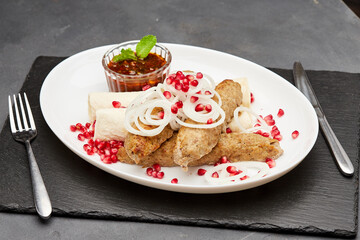 Traditional grilled kebab with pomegranate, onions, spicy sauce for flavorful culinary experience