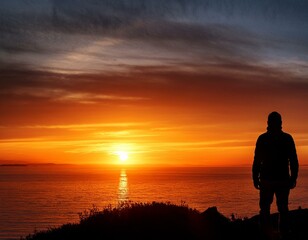 Fototapeta premium A lone figure silhouetted against a vibrant sunset, contemplating the horizon.
