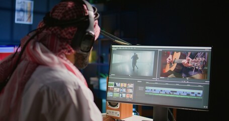 Middle Eastern content creator editing cinematographic project in post production process, working with images and sounds. Teleworking artist doing video selection on computer screen