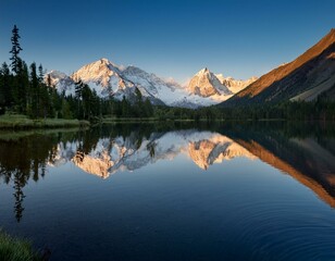 A serene mountain lake reflecting the snow-capped peaks at dawn.