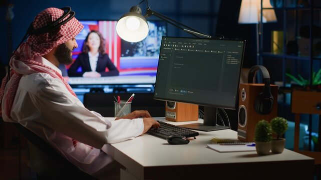 Qualified arab programmer writing code on computer screen while in office using Java programming languages. Middle Eastern Developer working on fixing database errors while working from home