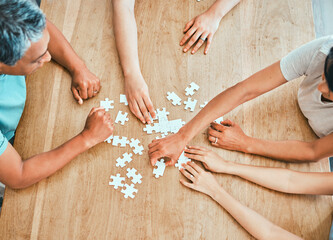Collaboration, hands and puzzle with group of business people at wooden table from above for...