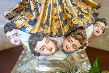 Obraz premium statues representing doll faces at the feet of a saint.