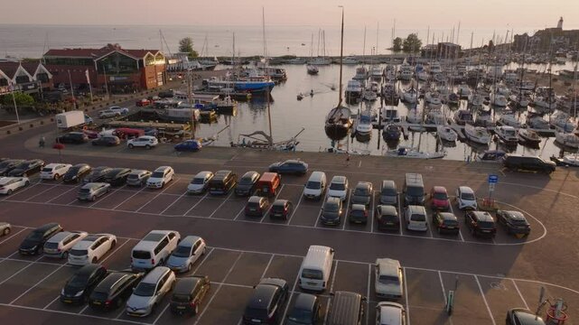 Aerial view of Urk's marina and busy parking lot at sunset, capturing the lively atmosphere of this charming coastal town in the Netherlands