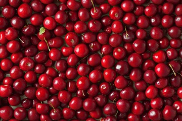 A close-up shot of many red cherries. This photo can be used for background, food blogs, and product marketing materials.