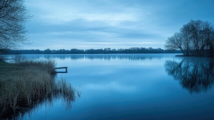Fototapeta premium Blue hour over a calm lake, tranquil and serene twilight landscape, soft reflections