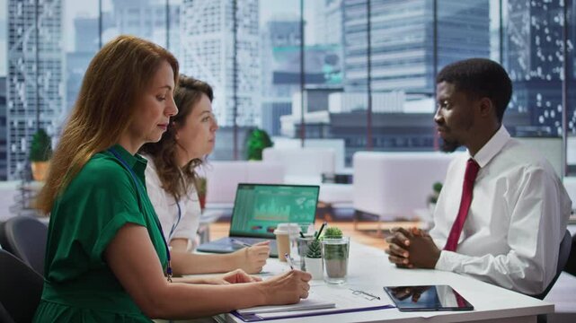 HR recruiters interviewing a job seeker and taking notes during meeting, attending an interview and conducting an evaluation. Headhunters and applicant in recruitment process. Close up. Camera B.