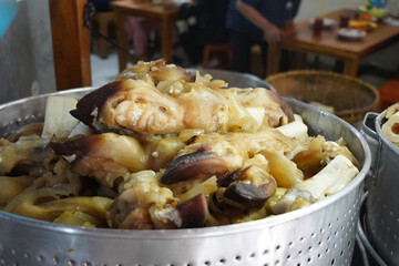 A large pot filled with cooked cow's fee.