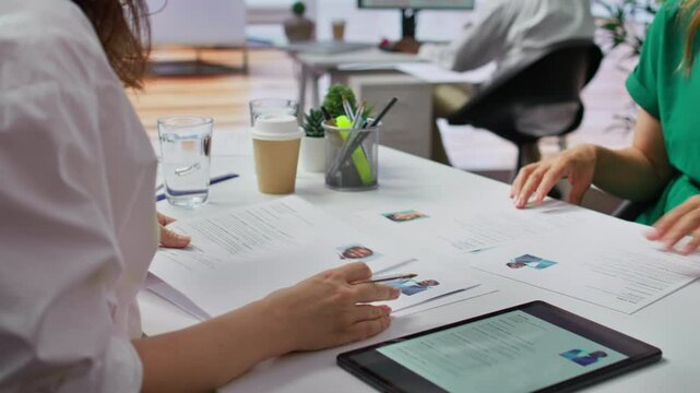 Team of recruiters selecting candidates based on their resumes, looking for the right person to fill in job vacancy. HR staff evaluating the qualifications of applicants after interview. Camera B.